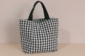 Black and white checkered tote bag on a light gray background