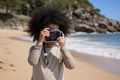 Child holding a vintage camera on a beach