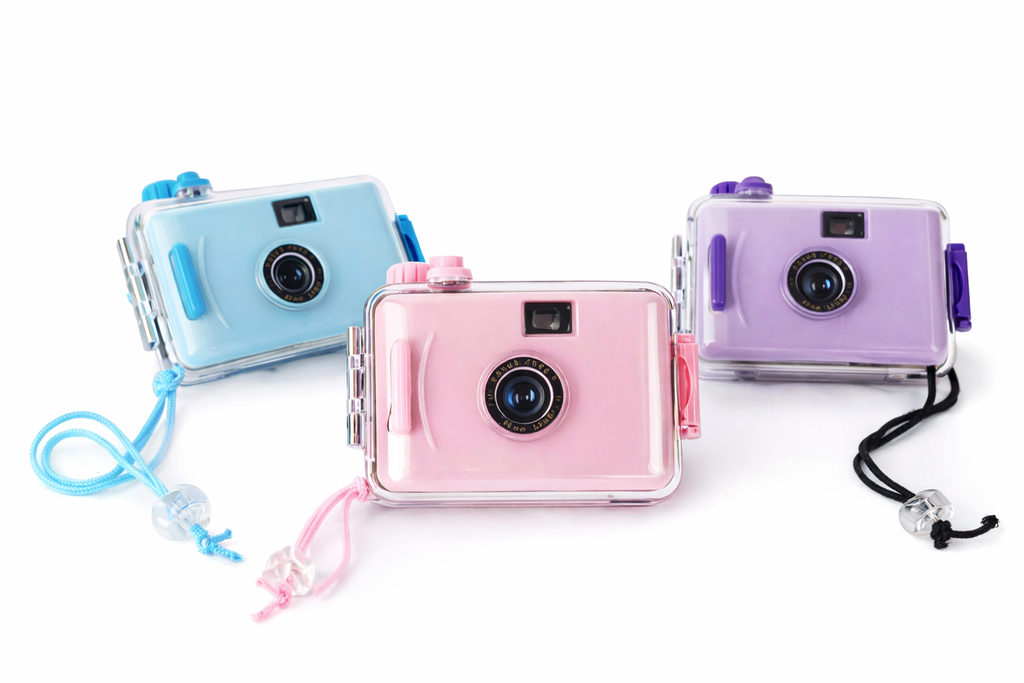 Three colorful disposable cameras with lanyards on a white background