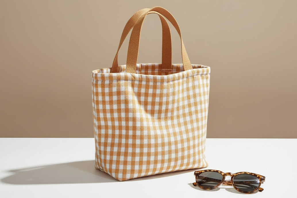Orange checkered bag with wooden handles on a polka dot curtain background