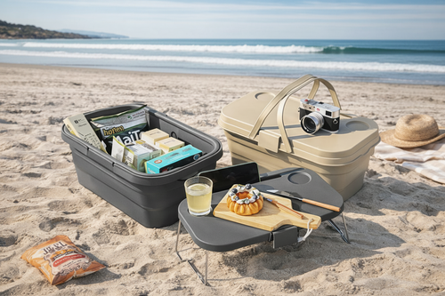 Picnic setup on a sandy beach with a cooler, table, and food items.