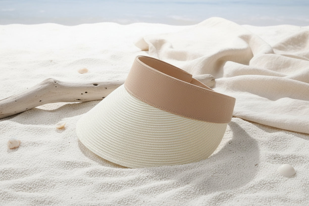 Two-toned straw visor on a white surface with a magazine underneath