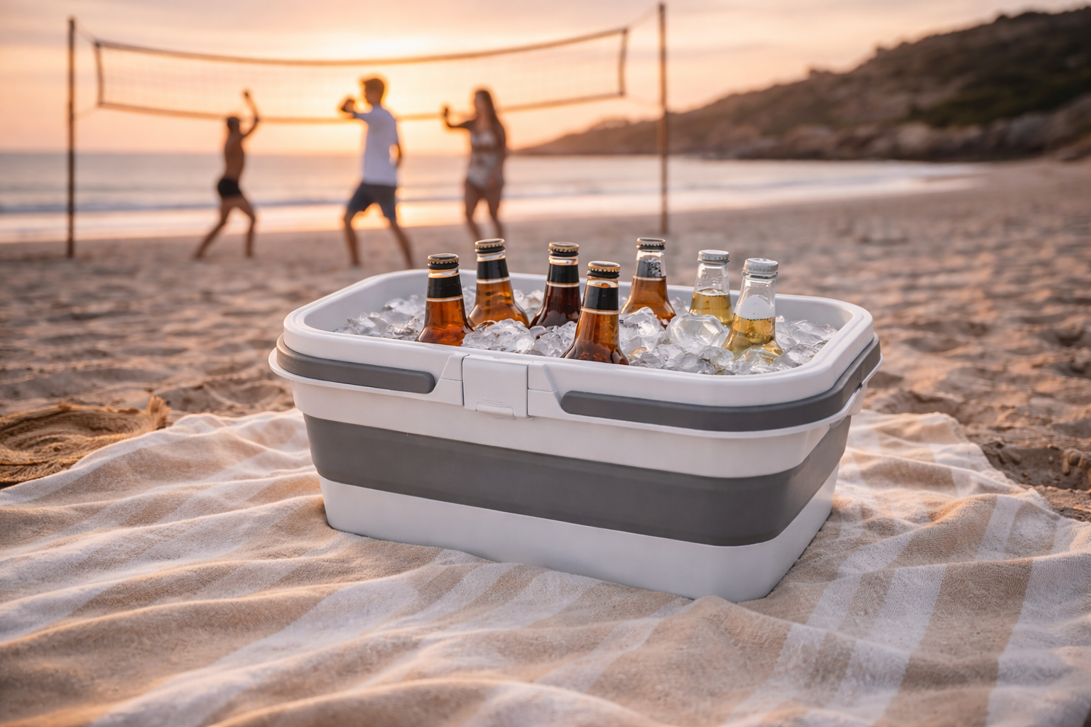 Collapsible cooler with ice and bottles on a beach with people playing volleyball in the background.