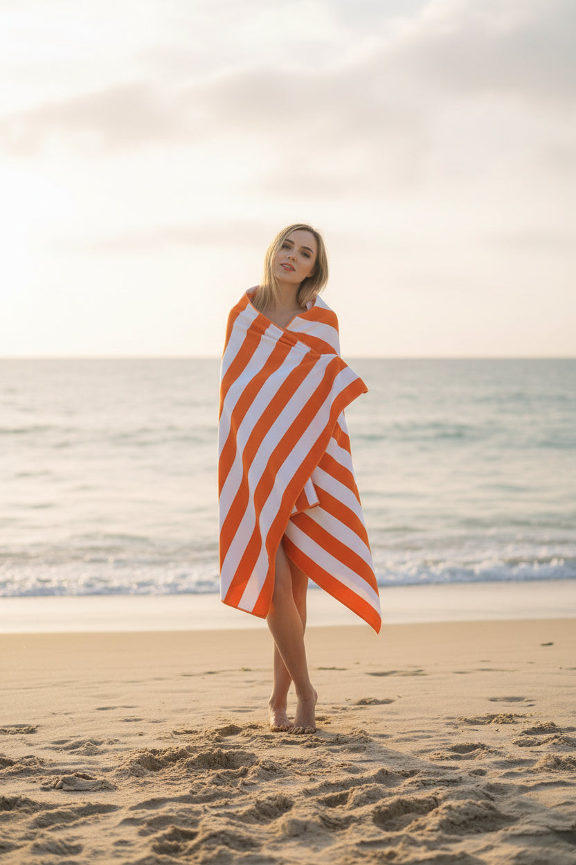 Woman wrapped in an orange and white striped towel on a white background